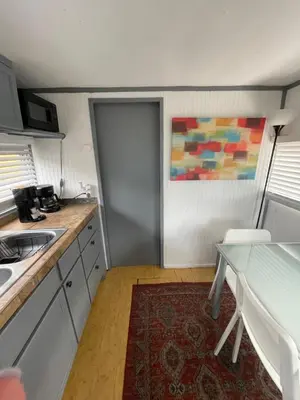 a kitchen with a door and a table and a painting at Updated houseboat on the river! in Fort Lauderdale
