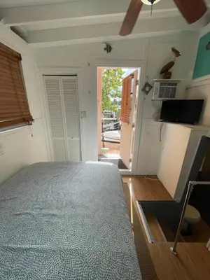 a bedroom with a bed and a door to a porch at Updated houseboat on the river! in Fort Lauderdale