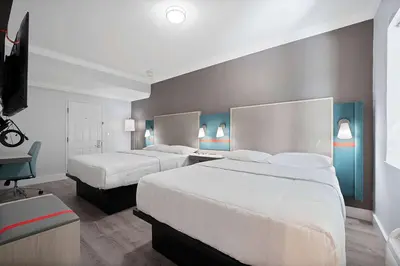 a hotel room with two beds and a desk at Atrium Hotel, Trademark Collection by Wyndham in Miami