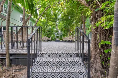 a metal gate leading into a courtyard with trees at Atrium Hotel, Trademark Collection by Wyndham in Miami