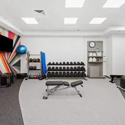 a room with a gym with chairs and a clock at Hilton Garden Inn Ft. Lauderdale Airport-Cruise Port in Dania Beach