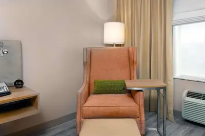 a chair with a green pillow in a room at Hilton Garden Inn Ft. Lauderdale SW/Miramar in Miramar