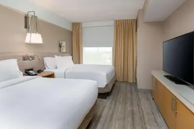 a hotel room with two beds and a flat screen tv at Hilton Garden Inn Ft. Lauderdale SW/Miramar in Miramar
