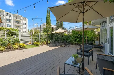 a patio with an umbrella and tables and chairs at Baybreeze Apartments by Lowkl in Miami Beach