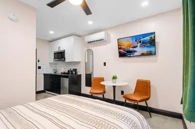 a bedroom with a bed and a table and chairs at Baybreeze Apartments by Lowkl in Miami Beach