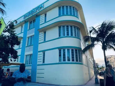 a woman sitting in front of a building at Beach House BEACHFRONT STUDIO 107 in Miami Beach