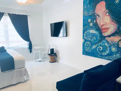 a living room with a painting of a woman on the wall at Beach House BEACHFRONT STUDIO 107 in Miami Beach