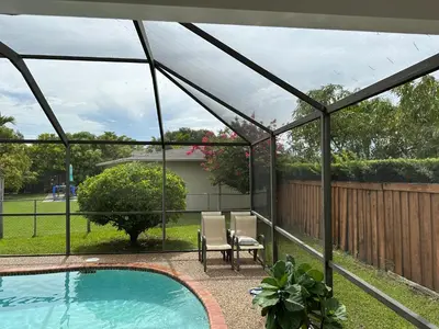 a screened in patio with a pool and a chair at 82-10SW 135AV in Miami