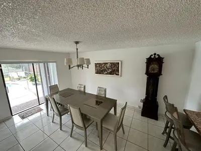 a dining room with a table and a grandfather clock at 82-10SW 135AV in Miami