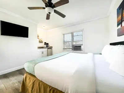 a white bedroom with a bed and a ceiling fan at The Palms in Hollywood