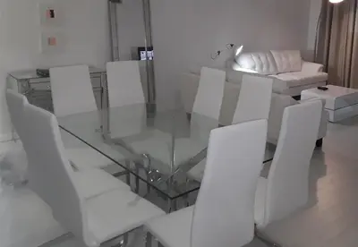 a dining room with a glass table and white chairs at Tides Apt on Hollywood Beach in Hollywood