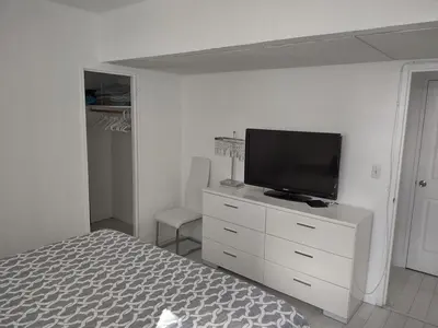 a bedroom with a bed and a television on a dresser at Tides Apt on Hollywood Beach in Hollywood