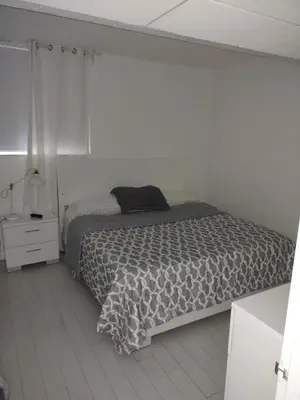 a white bedroom with a bed and a night stand at Tides Apt on Hollywood Beach in Hollywood