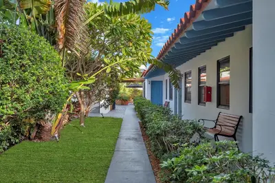 a walkway next to a house with a bench at Oasis Hotel in Fort Lauderdale