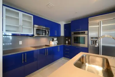 a kitchen with blue cabinets and stainless steel appliances at WVR Vacation Residences 506 in Fort Lauderdale