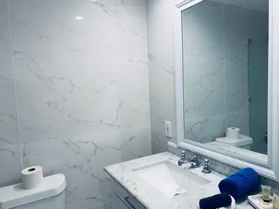 a white bathroom with a sink and a mirror at SOBE OCEAN VIEW OCEAN DR charming studio -316 in Miami Beach