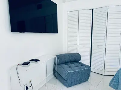 a living room with a chair and a flat screen tv at vacation home-ocean view SoBe 318 in Miami Beach