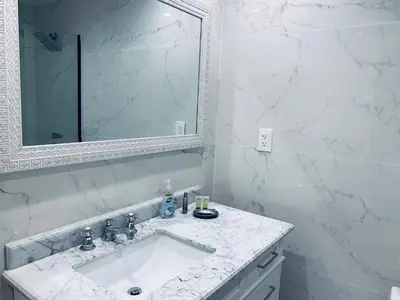 a white bathroom with a sink and a mirror at vacation home-ocean view SoBe 318 in Miami Beach