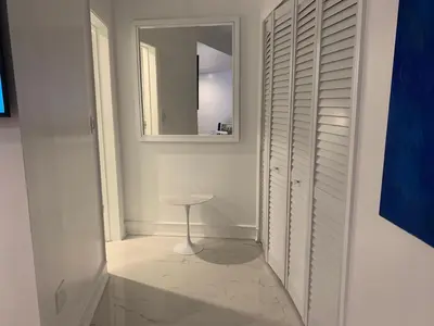 a white hallway with a stool and a mirror at vacation home-ocean view SoBe 318 in Miami Beach