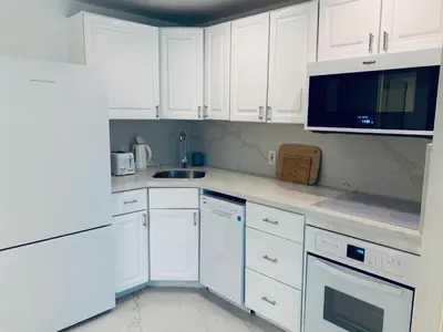 a white kitchen with white cabinets and a microwave at vacation home-ocean view SoBe 318 in Miami Beach