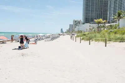 a woman standing on a beach with an umbrella at Miami Hollywood Two Bedroom Penthouse With Intracoastal View 005-22bvic in Hollywood