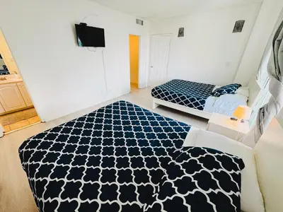 a bedroom with two beds and a tv on the wall at Miami Hollywood High Rise Condo 004-22bvic in Hollywood