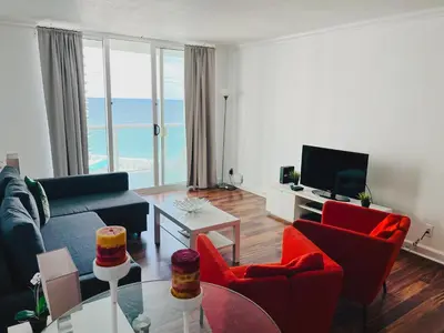 a living room with a blue couch and red chairs at Miami Hollywood Great 2BD Condo 009-21mar in Hollywood