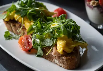 a white plate with a sandwich with lettuce and tomatoes at AC Hotel By Marriott Miami Brickell in Miami