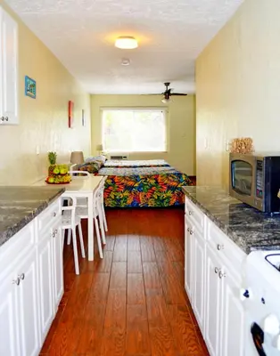 a kitchen with a bed and a kitchen with a table at Ocean Drive Villas in Hollywood