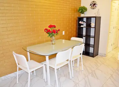 a table with chairs and a vase of flowers on it at Ocean Drive Villas in Hollywood