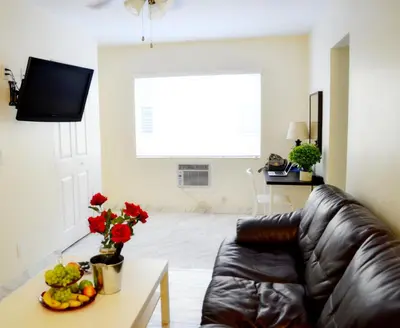 a living room with a leather couch and a table with fruit at Ocean Drive Villas in Hollywood