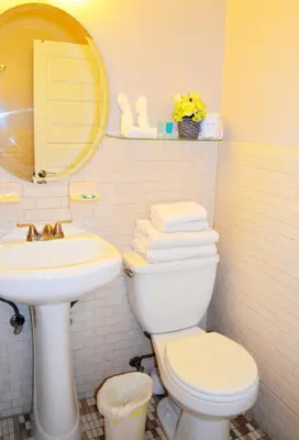 a bathroom with a sink and a toilet and a mirror at Ocean Drive Villas in Hollywood