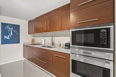 a kitchen with stainless steel appliances and wooden cabinets at Iconbrickell in Miami