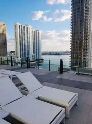 a balcony with white chairs and a view of the water at Iconbrickell in Miami