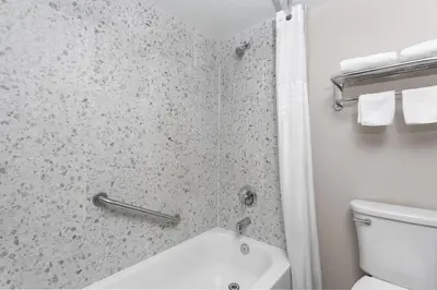 a bathroom with a shower and a toilet and a sink at Super 8 Motel by Wyndham near Fort Lauderdale Arpt in Dania Beach