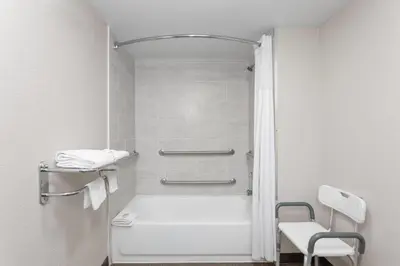 a bathroom with a shower and a white toilet at Super 8 Motel by Wyndham near Fort Lauderdale Arpt in Dania Beach