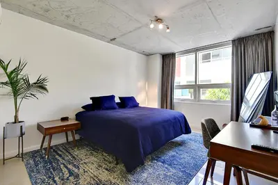 a bedroom with a blue bed and a piano at Miami Midtown Luxury Apartment in Miami