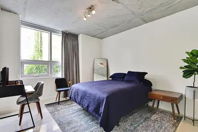 a bedroom with a bed with a purple bedspread and a desk at Miami Midtown Luxury Apartment in Miami