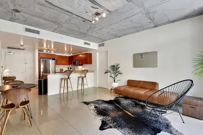 a living room and kitchen with a couch and chairs at Miami Midtown Luxury Apartment in Miami
