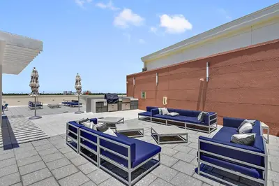 a patio with blue chairs and tables and a building at Miami Midtown Luxury Apartment in Miami