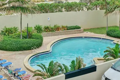 a swimming pool in a yard with chairs and trees at Luxury Beachfront Apartments 4001 S Ocean Dr in Hollywood