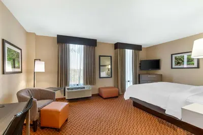 a large hotel room with a bed and a desk at Best Western Plus Kendall Hotel & Suites in Kendall