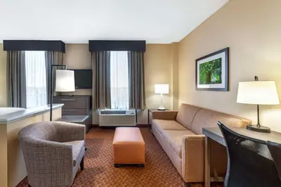 a living room with a couch and chairs in a hotel room at Best Western Plus Kendall Hotel & Suites in Kendall