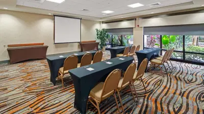 a conference room with tables and chairs and a screen at Best Western Plus Kendall Hotel & Suites in Kendall
