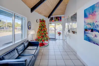 a living room with a christmas tree and a couch at Leeward Motel By Capital O North Miami Beachside in North Miami