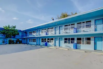 a blue building with a parking lot in front of it at Leeward Motel By Capital O North Miami Beachside in North Miami