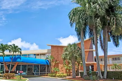 a building with palm trees in front of it at Knights Inn Hallandale in Hollywood