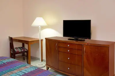 a bedroom with a dresser with a television on it at Knights Inn Hallandale in Hollywood