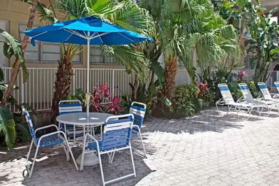 a table and chairs with a blue umbrella at Knights Inn Hallandale in Hollywood