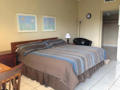 a bedroom with a bed and a desk and a chair at Knights Inn Hallandale in Hollywood